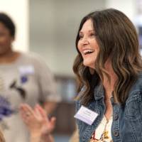 Woman standing while a crowd claps